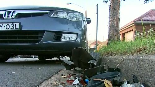 The gutter surrounding the crash was filled with wreckage from both the parked car and the Mitsubishi Magna.