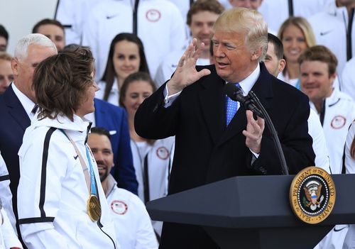 President Donald Trump listens to figure skater Vincent Zhou during a ceremony welcoming the Team USA Olympic athletes on North Portico at the White House in Washington.