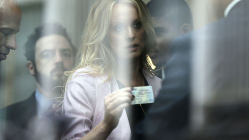 Stormy Daniels presents her identification as she arrives at the federal courthouse in  New York (AP)