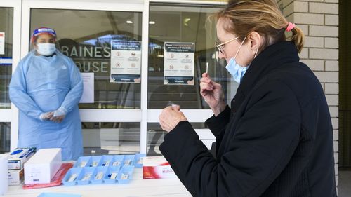 A worker at Whiddon Easton Park Age Care facility in Sydney uses a rapid test.