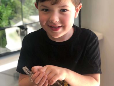 Young boy holding bearded dragon