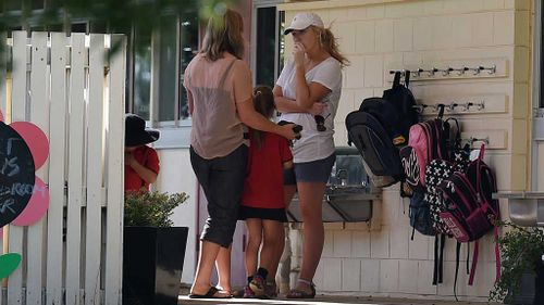 Parents talk to each other as they drop children off to school. (AAP)