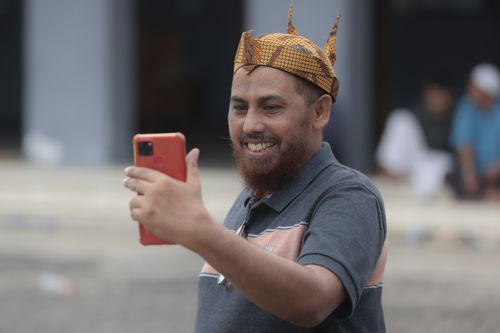 Indonesian militant Umar Patek uses his mobile phone to make a video call in Lamongan, East Java, Indonesia, Tuesday, Dec. 13, 2022. 