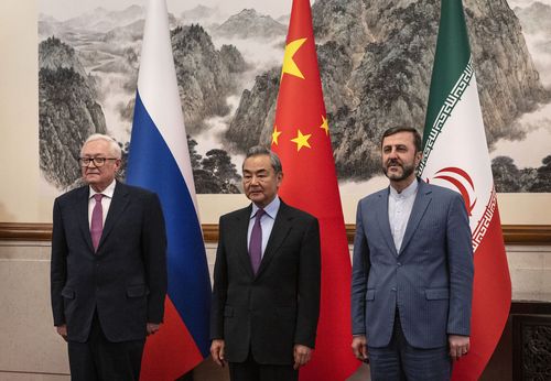 Chinese Foreign Minister Wang Yi, stands with Russian Deputy Foreign Minister Sergey Ryabkov, left, and Iranian Deputy Foreign Minister Kazeem Gharibabadi, right, before a meeting regarding the Iranian nuclear issue at Diaoyutai State Guest House on March 14, 2025 in Beijing, China. (Pool Photo via AP)