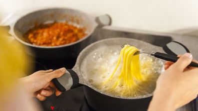 Woman cooking spaghetti