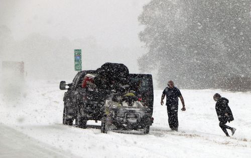 People attend to a vehicle that has broken down in Georgia last week. (AAP)
