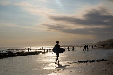 Bali, Indonesia - 4 June 2023: A surfer in Echo Beach in Canggu, Bali during sunset