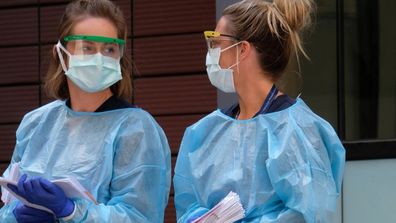 Hospital nursing staff assist people lining up for COVID-19 screening outside the Royal Melbourne Hospital  on March 11, 2020 in Melbourne, Australia. (Photo by Luis Ascui/Getty Images)