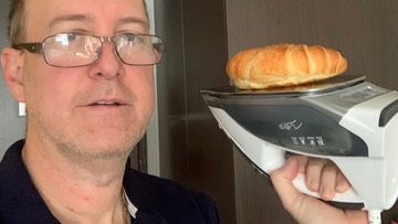 The Sydney dad heats up a croissant on an iron, while he is stuck in quarantine.