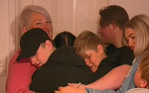 Big hug! The overjoyed family all huddled together after seeing their new home. 