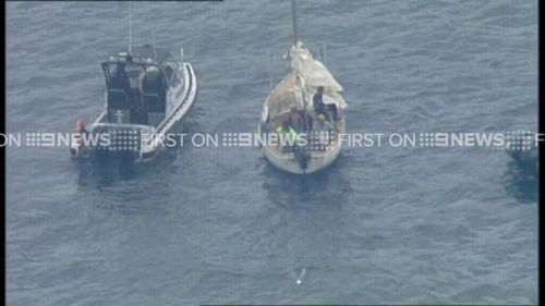 The police launch pulls alongside the craft. (9NEWS)