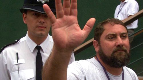 Damir Dokic  is escorted from the Wimbledon ground by a policeman on June 29, 2000. (AAP)
