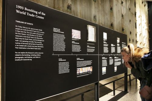 A visitor to the National September 11 Museum, in New York, Friday, Feb. 23, 2018, looks at a timeline of events of the Feb. 26, 1993 truck bomb attack at the World Trade Center. It was a terror attack that foreshadowed Sept. 11: the deadly World Trade Center bombing that happened 25 years ago Monday. (AP Photo/Richard Drew)