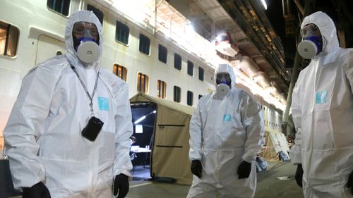 New South Wales Police investigators in protective gear prepare to board the Ruby Princess at Wollongong, Australia. Police boarded the cruise ship to seize evidence and question crew members after the vessel was linked to hundreds of COVID-19 cases and more than a dozen deaths across Australia.