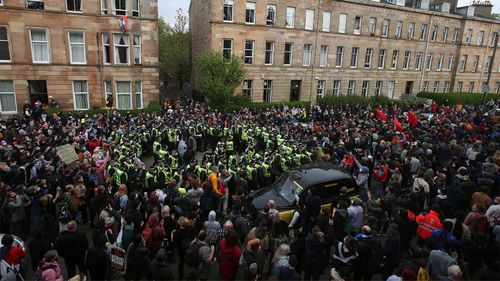 Protestors block a UK Home Office van to stop it from leaving with two arrested men.