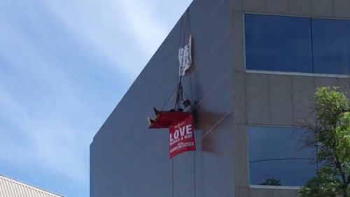 Two men are hanging in the tent above Bishop's Subiaco office in Perth. (9NEWS)