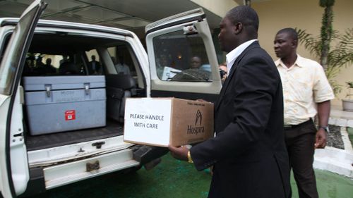 Liberian Deputy Health Minister Tolbert Nyenswuah carrys a box containing the Zmapp test drugs for Ebola patients in Liberia. (EPA/AHMED JALLANZO)