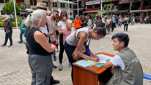 Turiștii fac coadă pentru a semna o petiție către compania de căi ferate pentru a fi evacuați într-un "Antrenamentul uman" în Machu Picchu, Peru, pe 20 ianuarie.