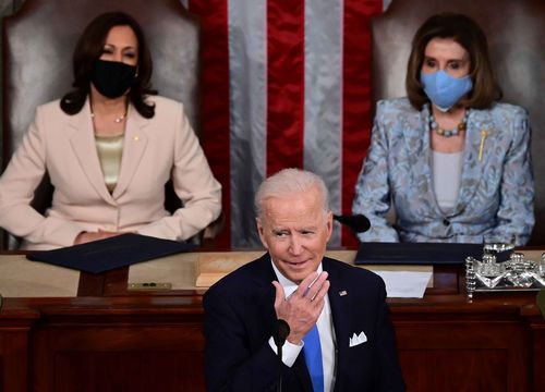 Joe Biden speaks to Congress, flanked by Kamala Harris and Nancy Pelosi.