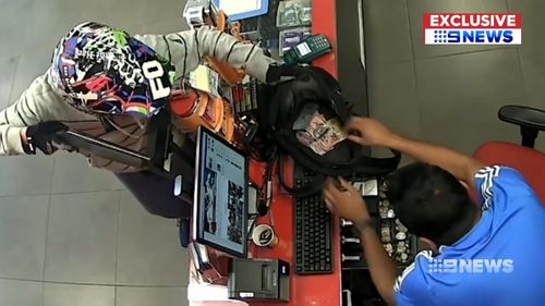 The worker obeys his every command - even handing over his own wallet. Picture: 9NEWS