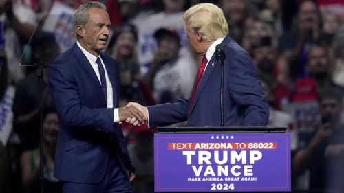 Robert F Kennedy Jr. shakes hands with Donald Trump during on his election rallies.