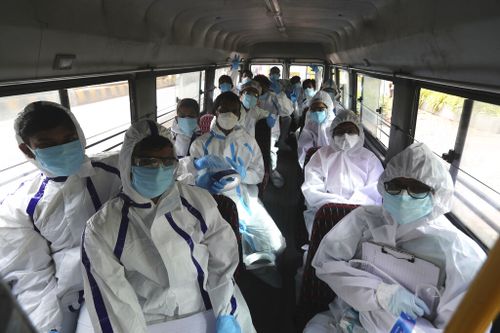 Health workers arrive on a bus to conduct a free medical checkup at residential building in Mumbai, India.