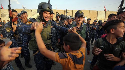Members of the Iraqi federal police dance with children during a celebration in the Old City of Mosul, where the gruelling battle to retake Iraq's second city from Islamic State fighters is now nearing its end. (AFP)