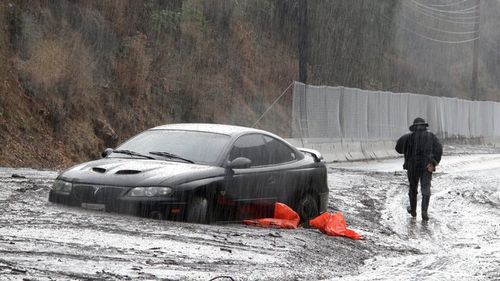 Damaged vehicles carried by mud flow and debris at the exit of the parking garage to The Montecito Inn on Tuesday. (AAP)