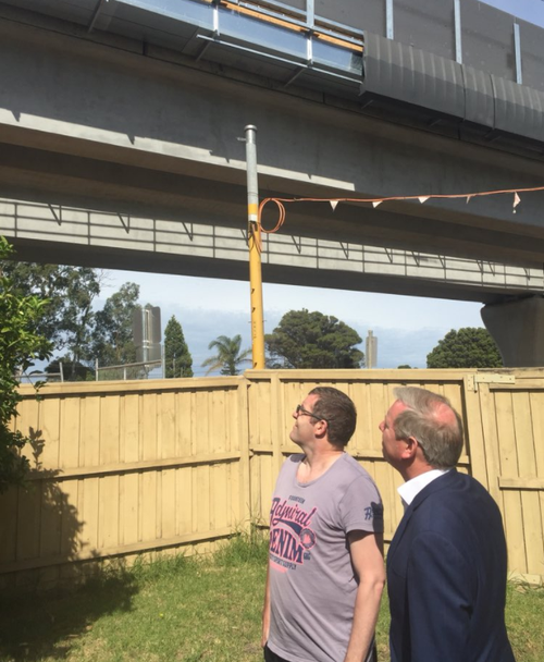 Noble Park resident Chris Papapavlou looks up at the SkyRail project hovering over his backyard. (Dougal Beatty / 9NEWS)