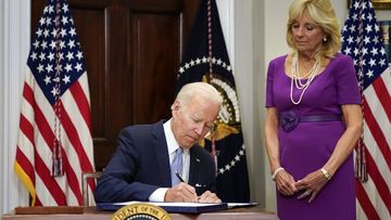 President Joe Biden signs into law S. 2938, the Bipartisan Safer Communities Act gun safety bill, in the Roosevelt Room of the White House in Washington, Saturday, June 25, 2022. First lady Jill Biden looks on at right.  