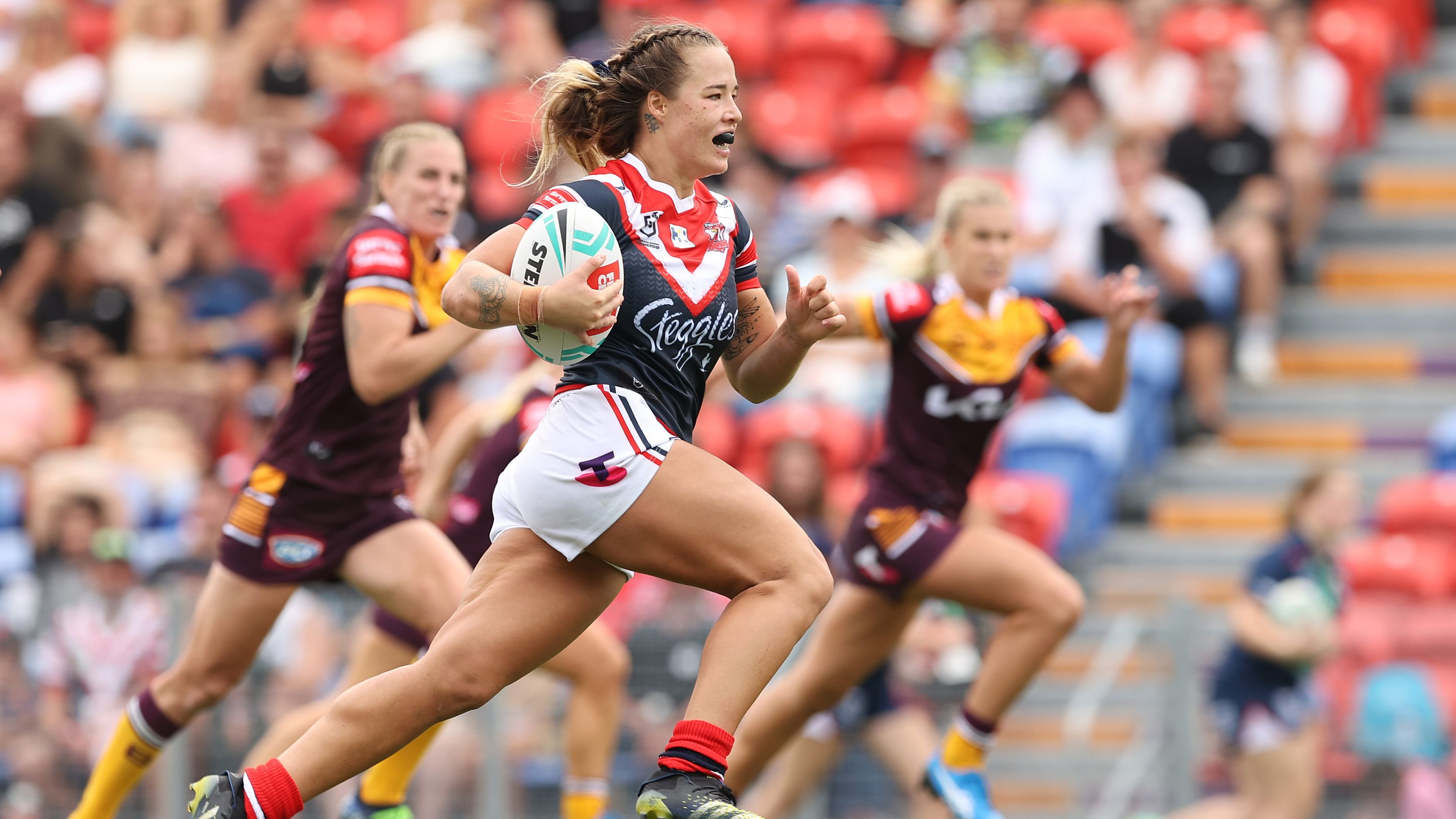 Isabelle Kelly of the Roosters makes a break during the round one NRLW match between the Sydney Roosters and the Brisbane Broncos.
