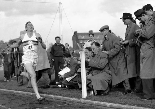 Sir Roger Bannister hits the tape to become the first person to break the four-minute mile in Oxford, England. (AAP)