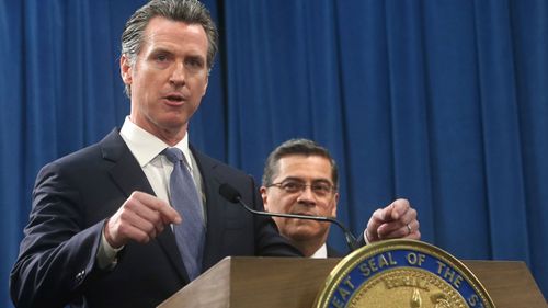 California Gov.ernor Gavin Newsom, left, flanked by Attorney General Xavier Becerra,