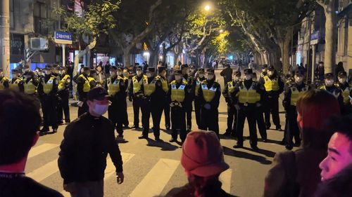Chinese police officers block off access to a site where protesters had gathered in Shanghai.