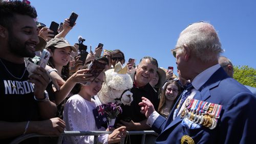 Britain's King Charles III, tight, chat with owner of alpaca before leave the Australian War Memorial in Canberra, Monday, Oct. 21, 2024.