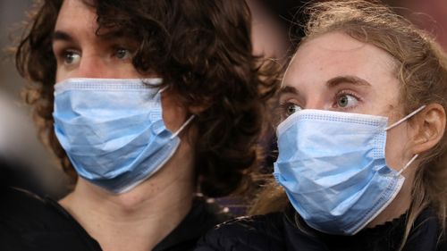 Spectators look on wearing face masks during the round 7 AFL match between the Geelong Cats and the Collingwood Magpies