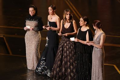 Melissa McCarthy, Rose Byrne, Kristen Wiig, Maya Rudolph, and Ellie Kemper speak onstage during the 98th Oscars at Dolby Theatre on March 15, 2026 in Hollywood, California. 