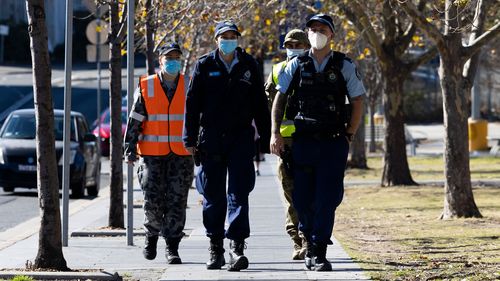 Australian Defence Force soldiers and members of the New South Wales Police Force patrol in the Bankstown CBD.