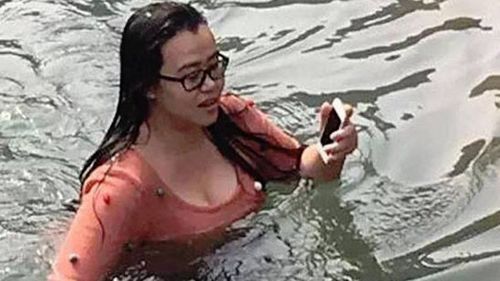 Chinese woman dives into chilly lake to save her iPhone 5