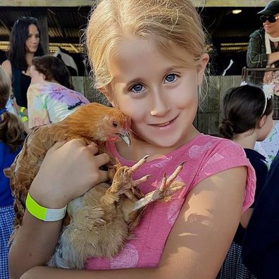 Laura Everson as a child holding a chicken.