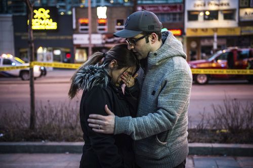 Farzad Salehi consoles his wife, Mehrsa Marjani, who was at a nearby cafe and witnessed the carnage. Picture: AP/The Canadian Press