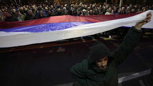 People hold giant Serbian flag during a protest against the Serbian authorities and French-German plan for the resolution of Kosovo, in Belgrade, Serbia, Wednesday, Feb. 15, 2023. Hundreds of pro-Russia nationalists have rallied outside the Serbian presidency building demanding that President Aleksandar Vucic reject a Western plan for normalization of ties with breakaway Kosovo and pull out of negotiations. Shouting Treason and carrying banners reading No surrender, the protesters on Wednesday b
