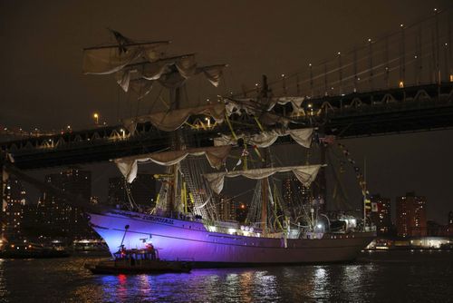 A New York Police Department harbor unit passes in front of the CuauhtÃ©moc, a masted Mexican Navy training ship as it sits stranded near the Manhattan Bridge after colliding with the Brooklyn Bridge.