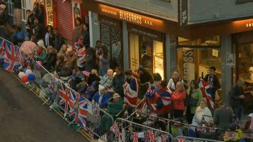 Fans line the streets at sunrise.