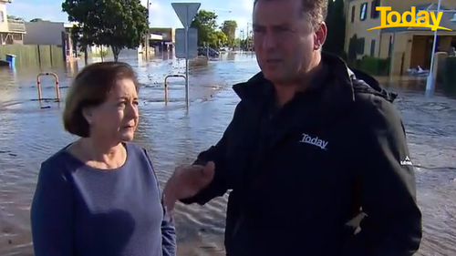 Ballina Shire Mayor Sharon Cadwallader speaks to Today host Karl Stefanovic in calf-deep water.