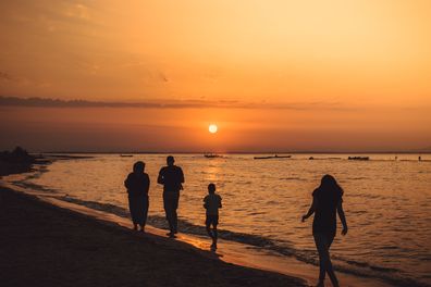 Family on beach at sunset