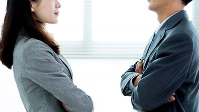 Man versus woman battle of the sexes male female arms crossed office rivalry