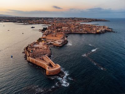 Aerial view of Ortigia Island and Siracusa city at sunset. Landmark in Sicily, Italy.