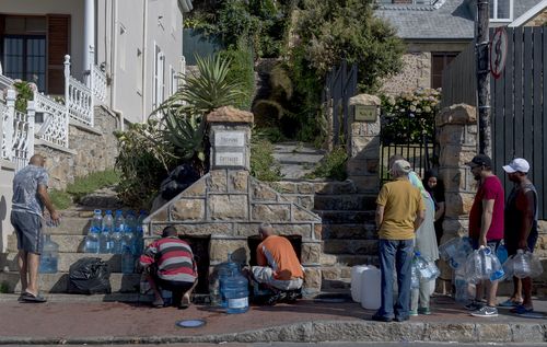 People queue to collect water from a natural spring in the Cape Town, South Africa. (AAP)