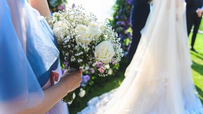 Bridal bouquet in the bridesmaid hand at the wedding ceremony